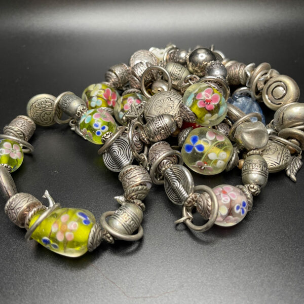 Assorted bracelets with hanging icons.