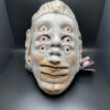 Head mask of six eyes, three noses, and two lips.