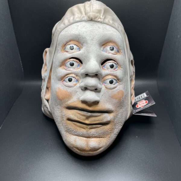 Head mask of six eyes, three noses, and two lips.