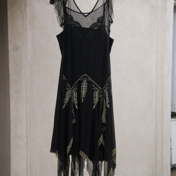 A vintage woman dress hanging on the outside awning of Pok-A-Dots Costumes.