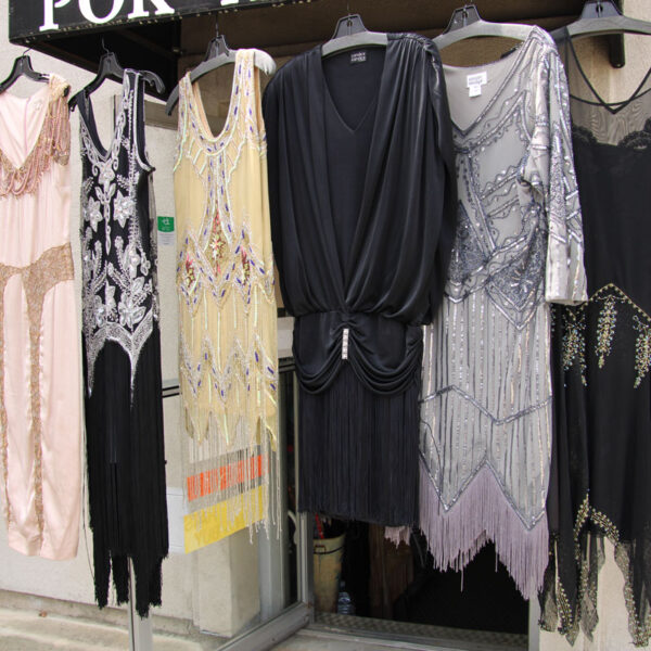 Assorted vintage women dresses hanging on the outside awning of Pok-A-Dots Costumes.