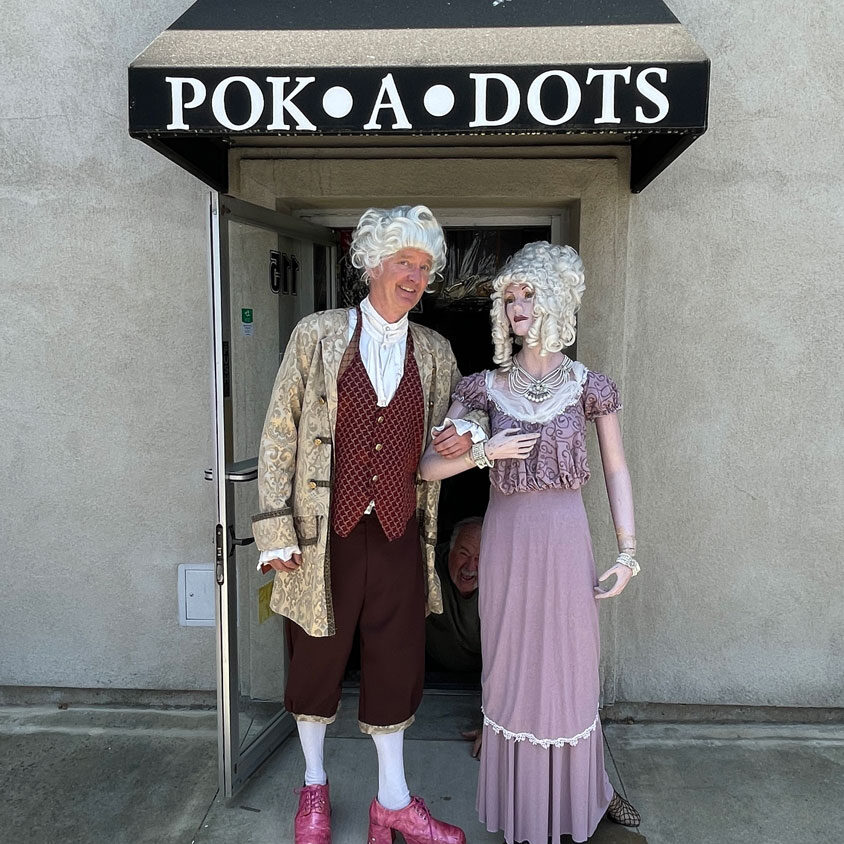 Man dress in vintage costumes and a mannequin in vintage purple dress.