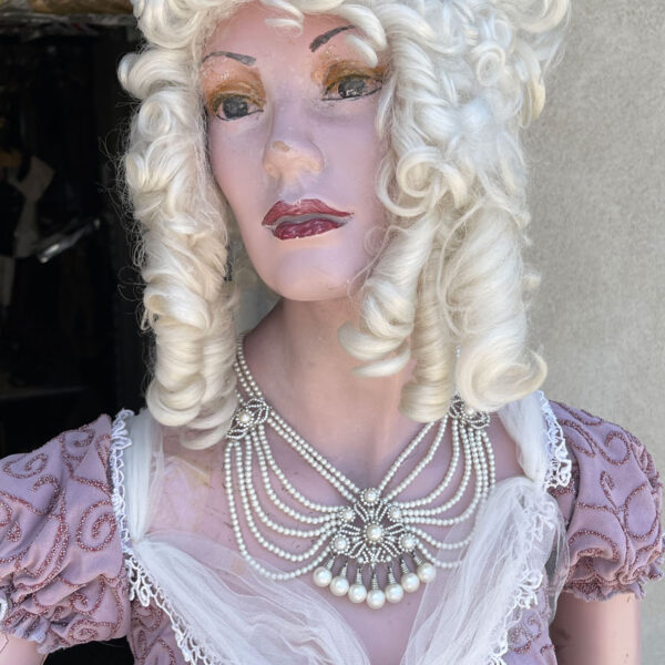 Lady mannequin in vintage purple dress.