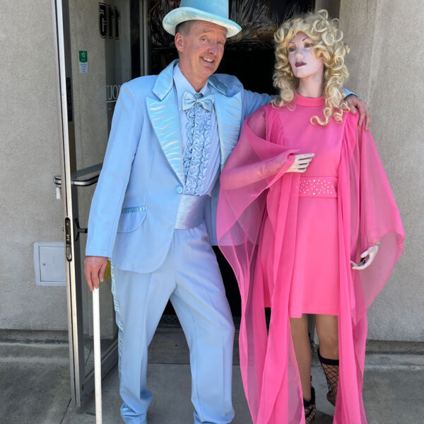 Man dressed in 20's blue suit with top hat and a lady mannequin in a pink dress.