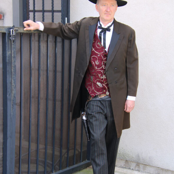 Man dress in a cowboy suite with gun holster.
