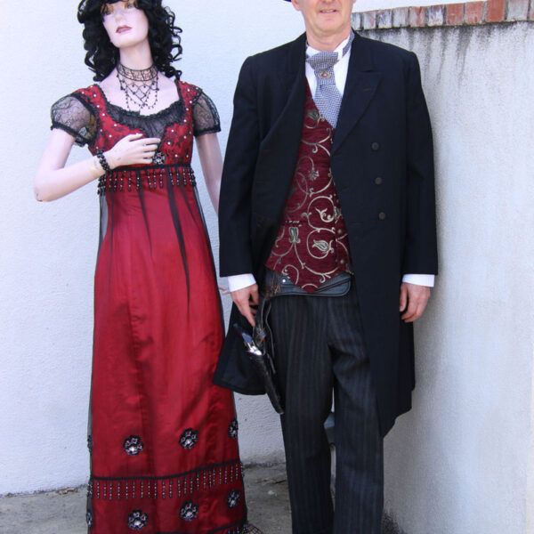 Man dressed in cowboy suite and lady mannequin in a red dress.