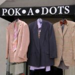 Men suits hanging from the sign of Pok-a-Dots awning.