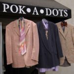Men suits hanging from the sign of Pok-a-Dots awning.