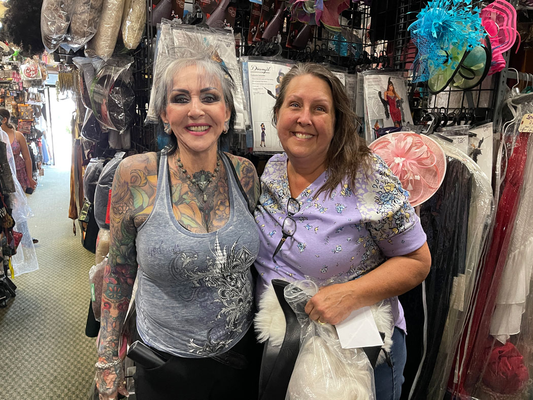 Arlene and Carie Nuss standing in front a costumes in Pok-a-Dots Costumes store.